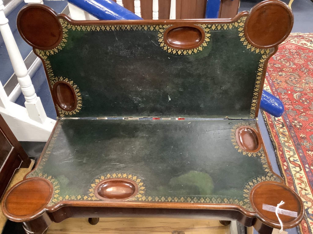 An 18th century mahogany games table, having shaped folding top enclosing counter wells and leather-lined surface on lappet-carved legs and pad feet, width 86cm depth 42cm height 72cm